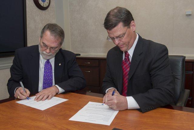 Dale Thomas, associate director-technical at NASA's Marshall Space Flight Center, and James Lackey signing the IPT agreement.