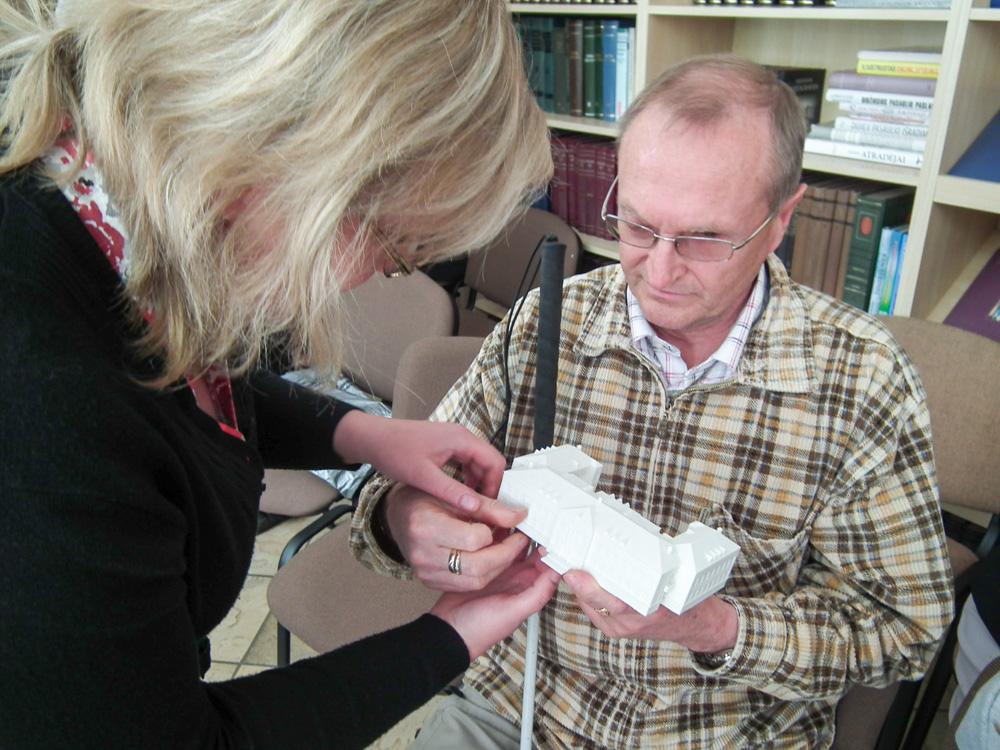 A visually impaired man touching a local school