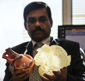 Dr. Joseph Vettukattil comparing an education heart model and Nicholas' 3D printed heart.