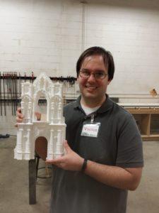 McIntyre with 3D printed piece for the Centennial Railway Garden exhibit
