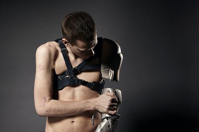 Young attaching his bionic arm to the harness that holds it in place.