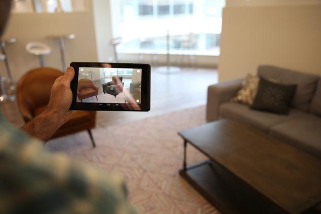 This May 2016 photo provided by Wayfair demonstrates the company's augmented reality app, WayfairView, which allows shoppers to visualize furniture and decor in their homes at full-scale before they make a purchase. Here, a chair that has been selected is virtually placed in a room to see how it fits and looks within the space. (Wayfair via AP) MANDATORY CREDIT