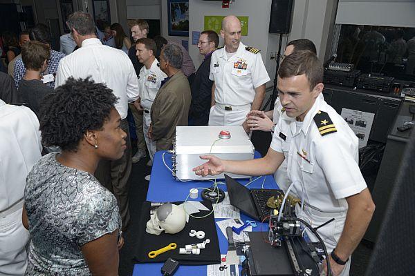 160621-N-YO707-269 Washington, D.C. (June 21, 2016) U.S. Navy Lt. Gregory Dejute, 3d project officer for Mid-Atlantic Regional Maintenance Center, explain to faire participant the benefits of Fab Lab during Capitol Hill Maker Faire in Washington, D.C., June 21, 2016. The Faire showcased robotics, drones, 3D printing and printed art. (U.S. Navy photo by Mass Communication Specialist 2nd Class Cyrus Roson/ Released)