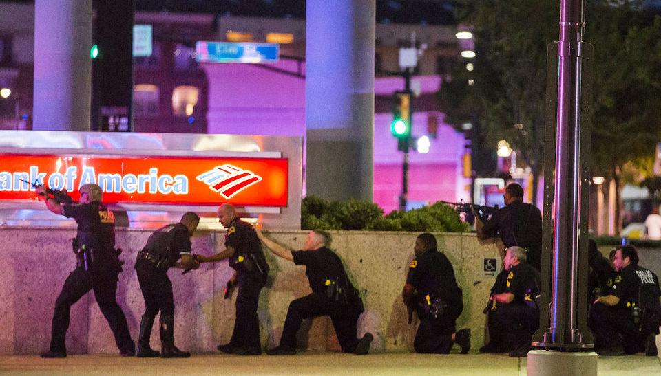 Dallas Police officers take cover while under fire.
