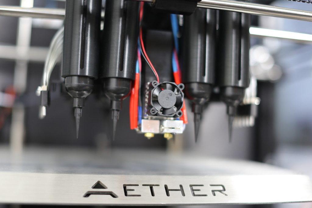 Shown with black plastic syringes with black extruder tips for optimum performance with UV curable materials. Printing stage also available in matte black anodized aluminum for ultimate anti-reflective photocrosslinking performance. (Photo: Aether)
