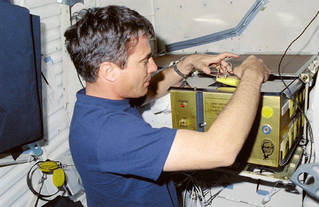 NASA astronaut John Blaha operates the "Chix in Space" experiment in orbit.