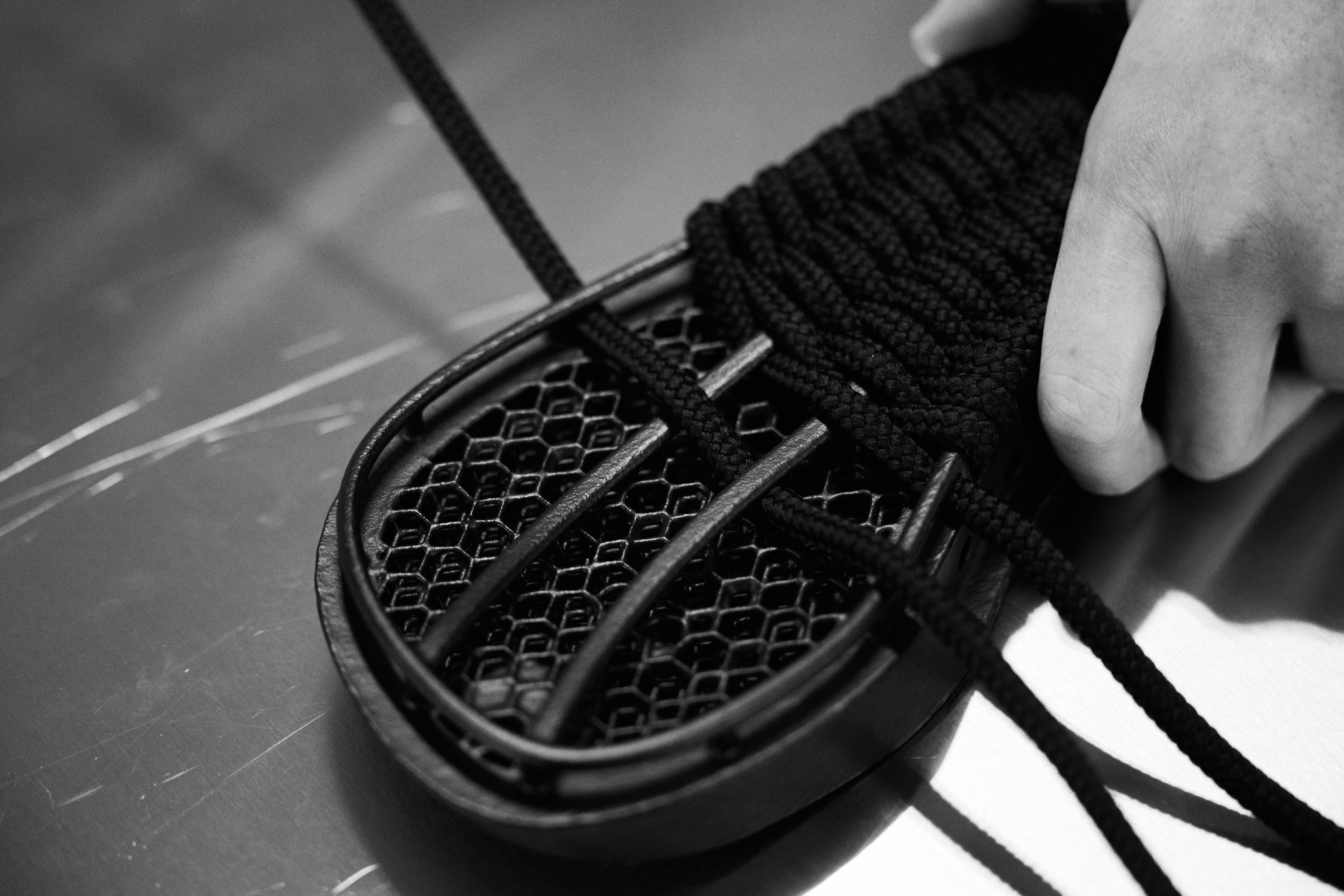Designer is hand weaving the 3D printed sole of a sandal.