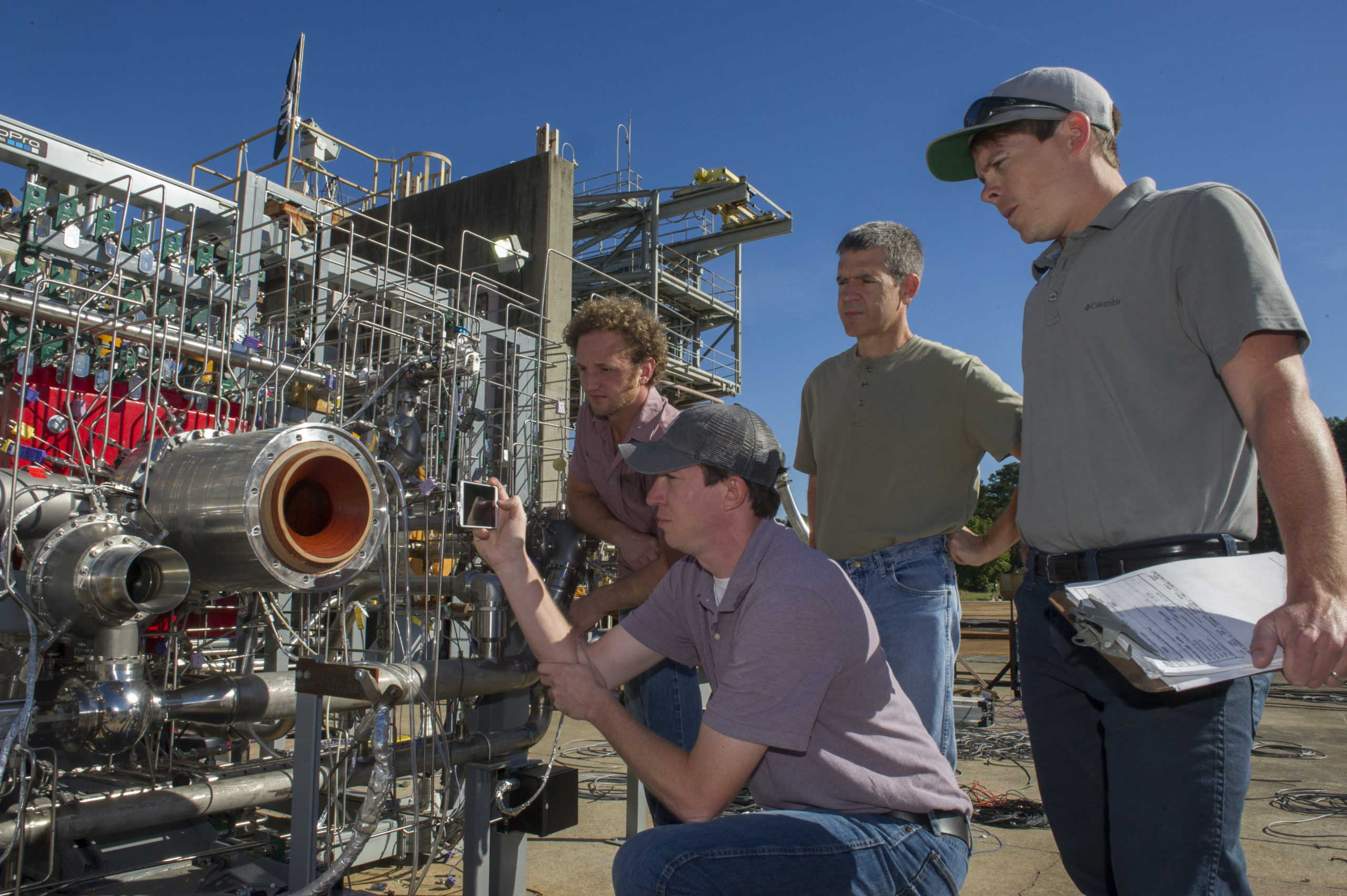 Engineers prepare a 3D printed engine for a test at NASA’s Marshall Space Flight